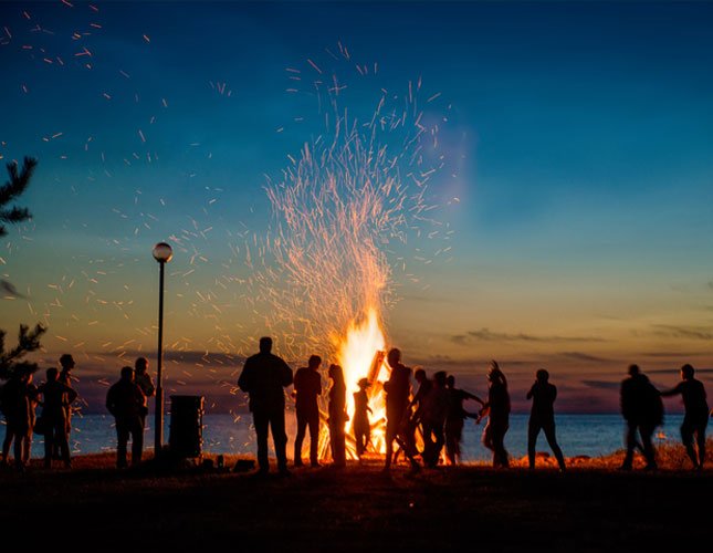 Guests around a night bonfire at Olorien Mara Camp, Masai Mara.