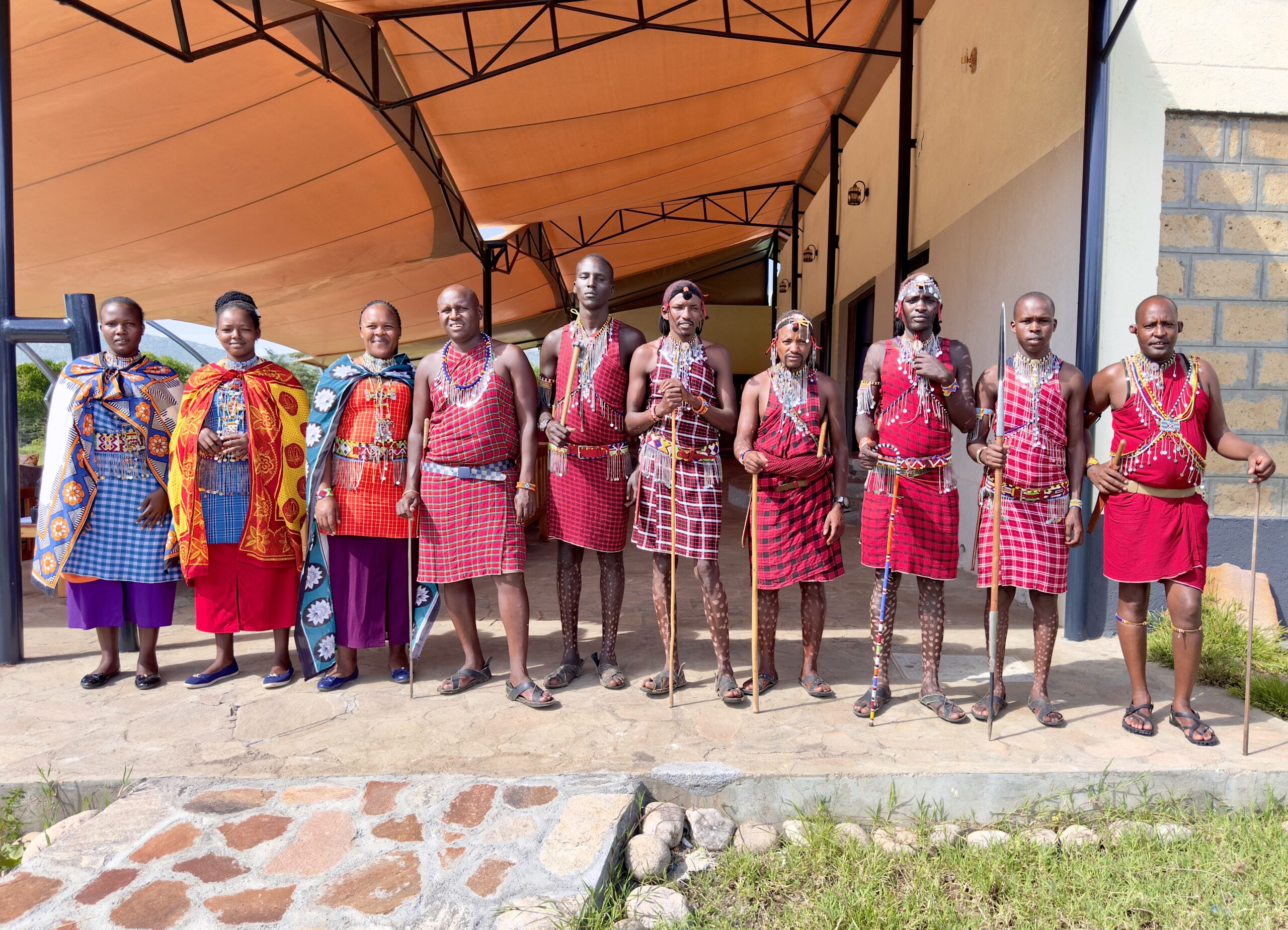 Traditional Maasai village near Olorien Mara Camp in Masai Mara, Kenya, featuring Maasai people in traditional attire.