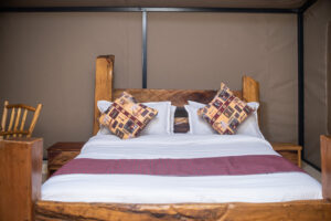 Luxury bed inside safari tent at Olorien Mara Camp, Masai Mara, Kenya